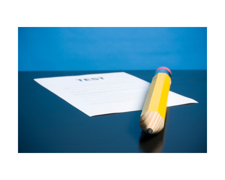 Pencil laying on top of a paper test with a blue background