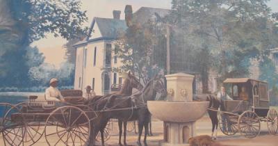 Horses drinking from water fountain in town